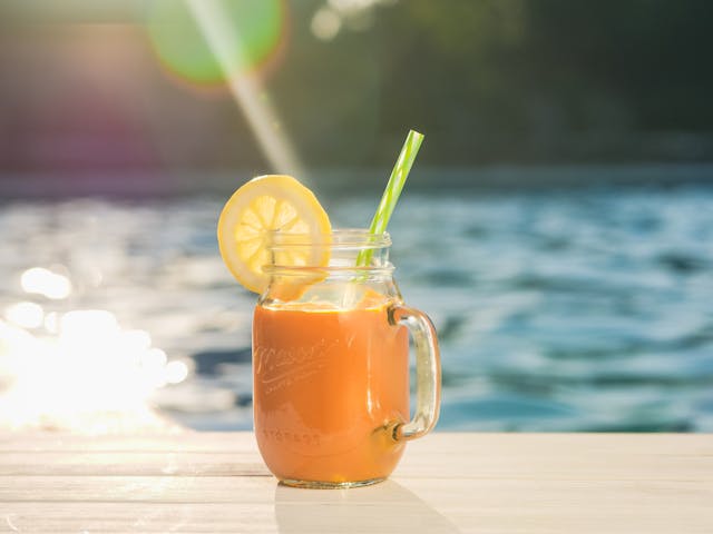 A glass of a tropical smoothie with a slice of lemon
